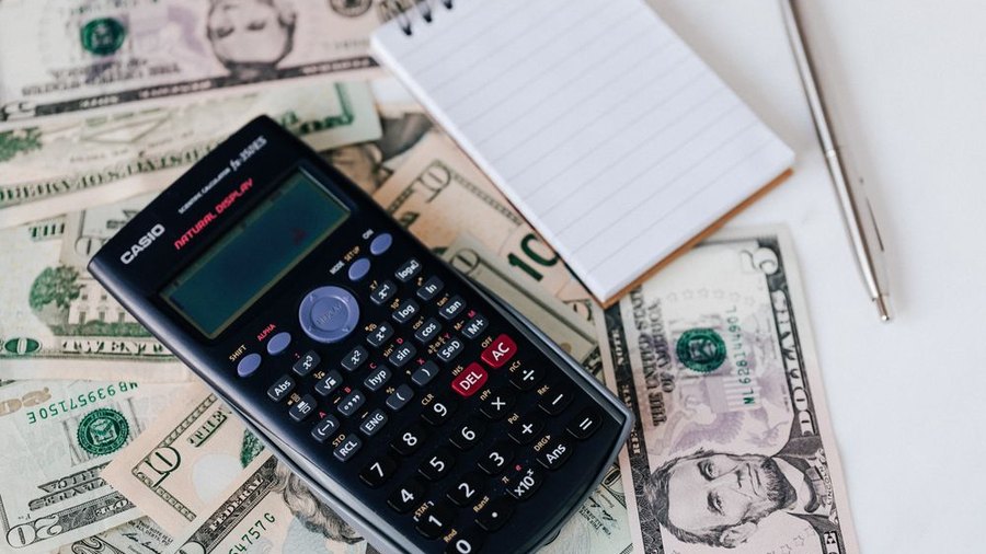 Calculator and cash representing answering service pricing